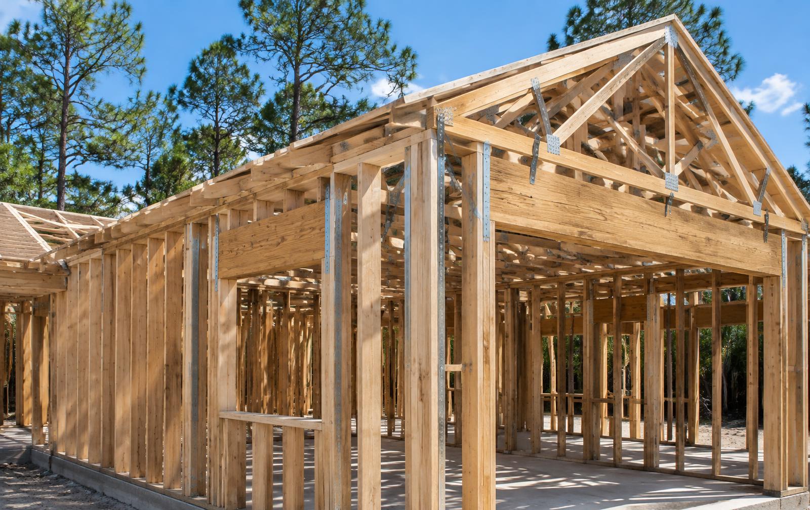Wood stud walls and roof trusses with metal hurricane straps on a home addition under construction